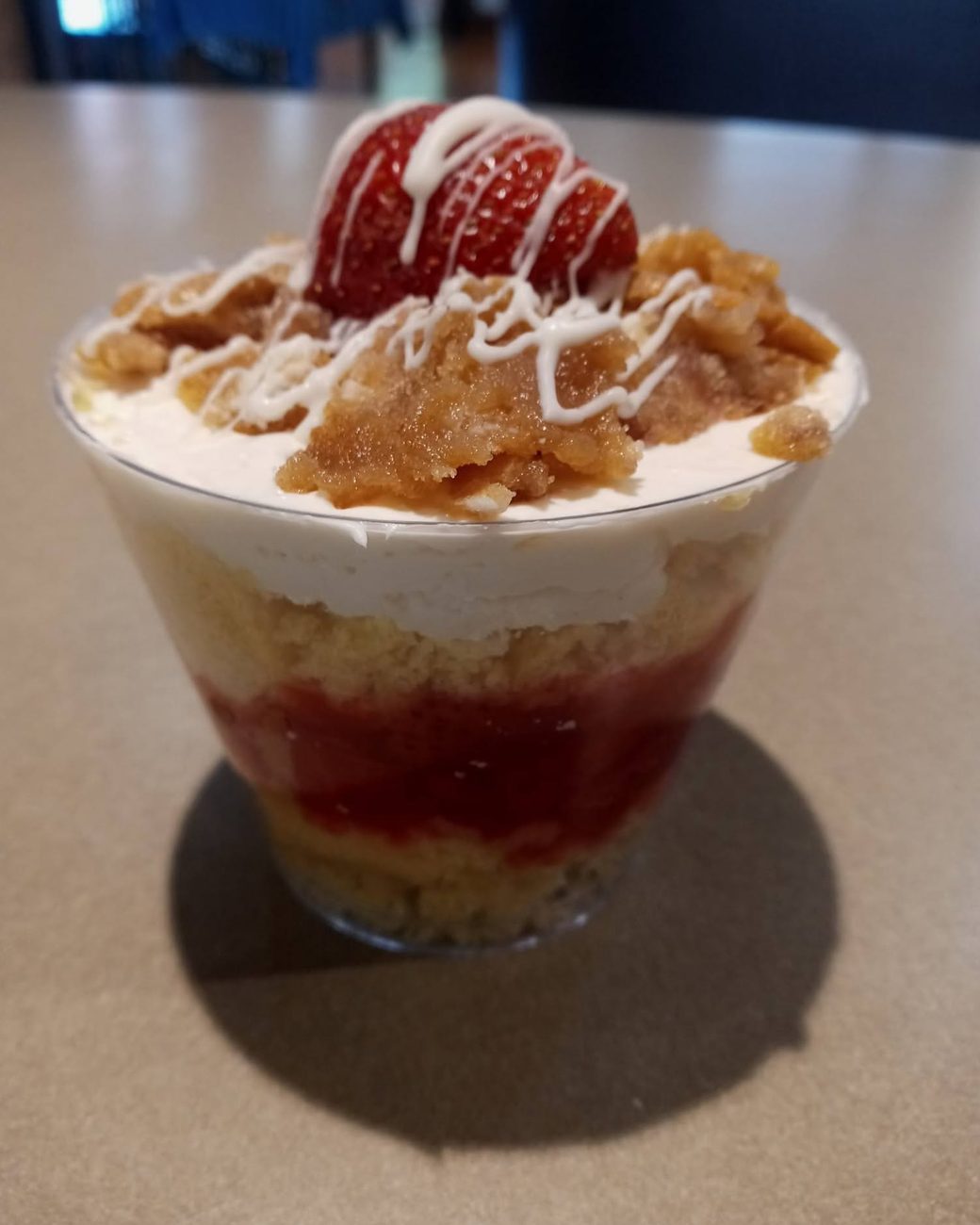 Strawberry shortcake parfait topped with a chocolate-drizzled berry
